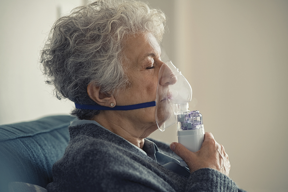 woman using nebulizer with mask