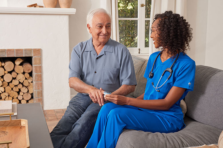 clinician using pule oximeter with patient in their living room