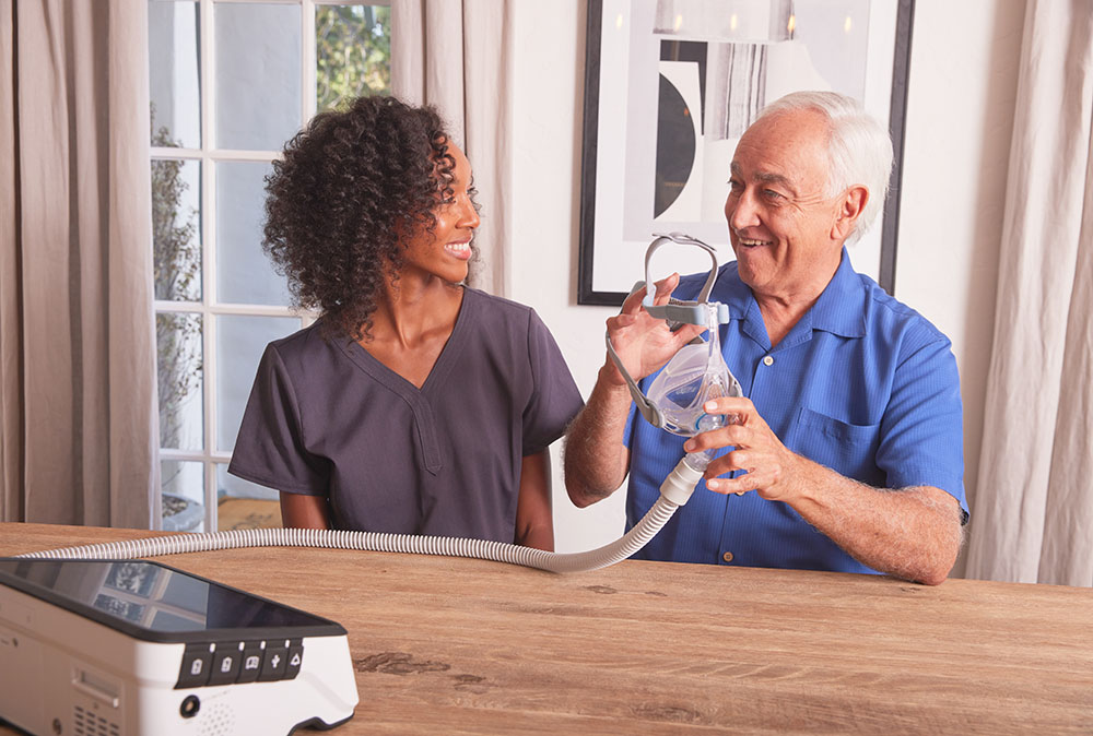 Non-Invasive Vent NHV Black Female Clinician White Male Sitting at Dining Table Ventilator Luisa2