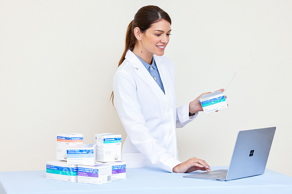 Pharmacy White Female Pharmacist Smiling Laptop Unit Dose Medications Albuterol SulfateIpratropium BromiseIprat